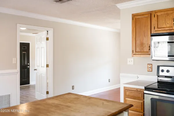 a view of a kitchen with wooden floor and electronic appliances