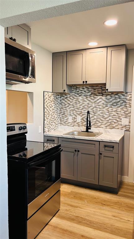 4603 Junius Street, Unit 4 Dallas, TX 75246 - Photo 4 of 14 a kitchen with stainless steel appliances granite countertop a sink stove and microwave