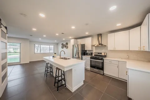 a kitchen with a sink white cabinets and stainless steel appliances
