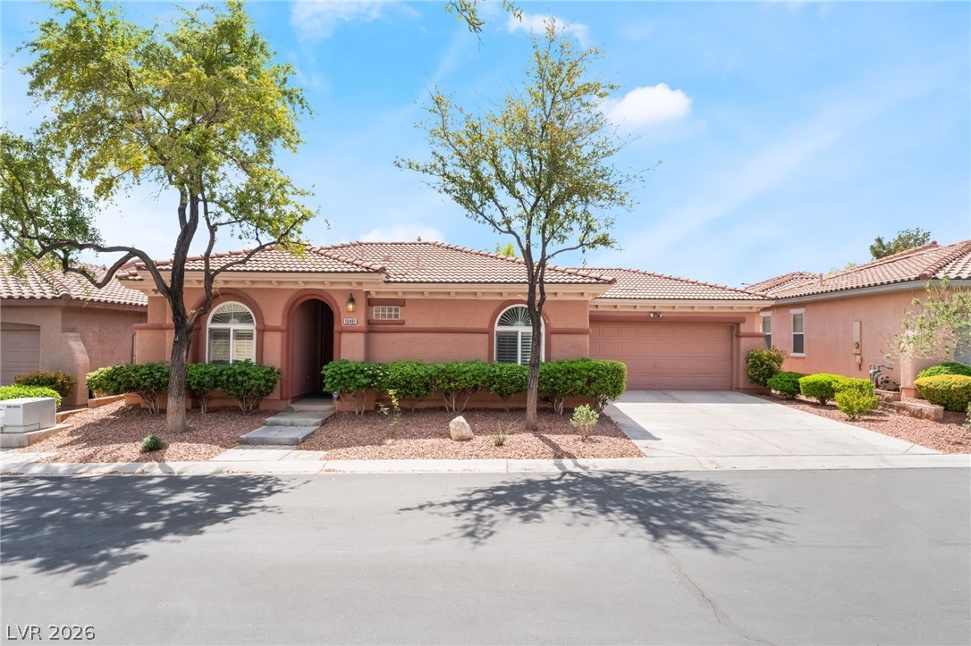 10481 Riverside Park Avenue Las Vegas, NV 89135 - Photo 1 of 51 Mediterranean / spanish home featuring an attached garage, driveway, stucco siding, and a tiled roof