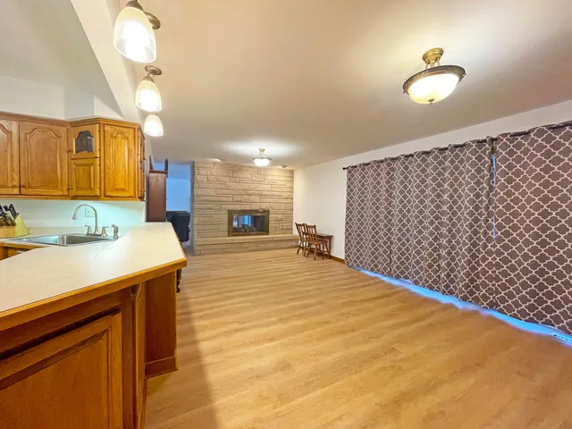 a kitchen with stainless steel appliances granite countertop a refrigerator a stove top oven and wooden floors