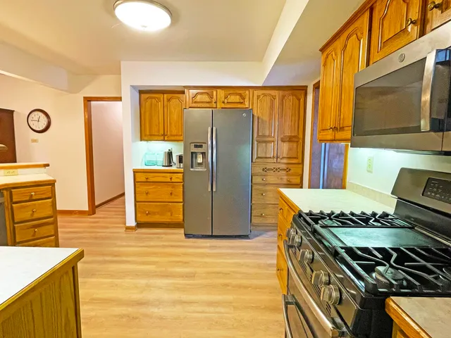 a kitchen with stainless steel appliances granite countertop a sink stove and wooden cabinets