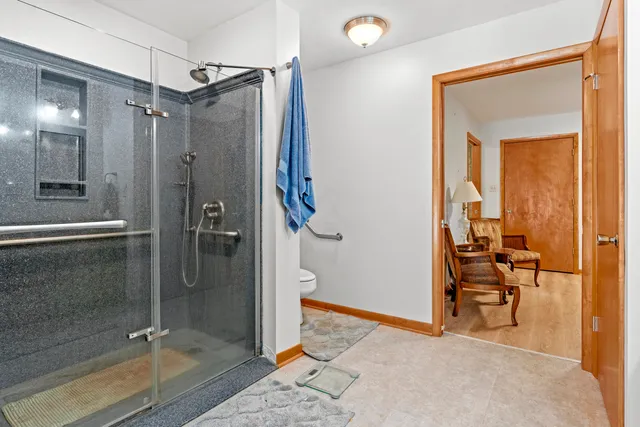 a bathroom with a granite countertop sink a mirror and shower