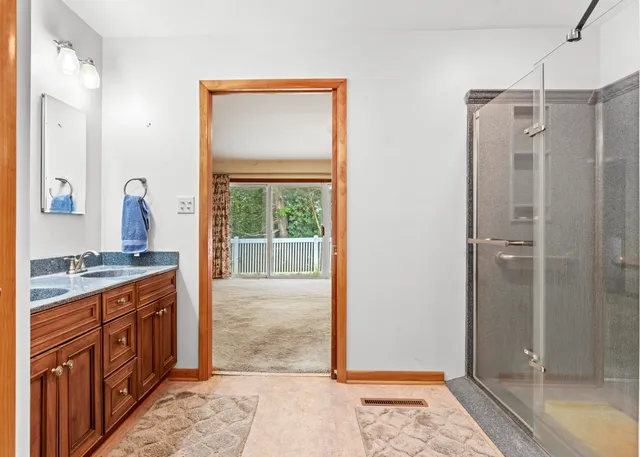 a bathroom with a granite countertop double vanity sink and a mirror