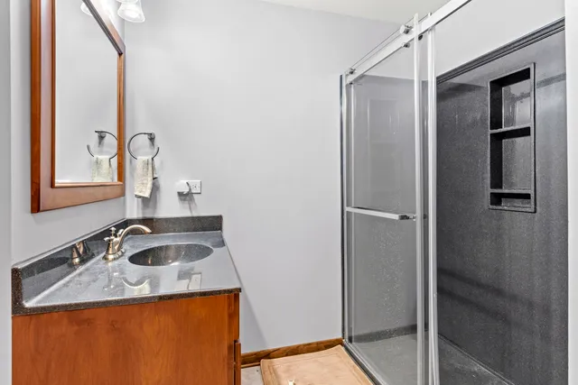 a bathroom with a granite countertop sink and a mirror