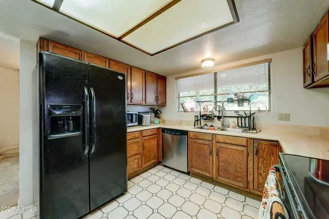 a kitchen with stainless steel appliances granite countertop a refrigerator and a sink
