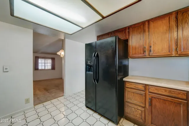 a view of a refrigerator in kitchen and cabinets
