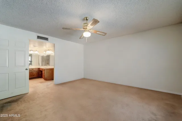 a view of a room with a ceiling fan and a window