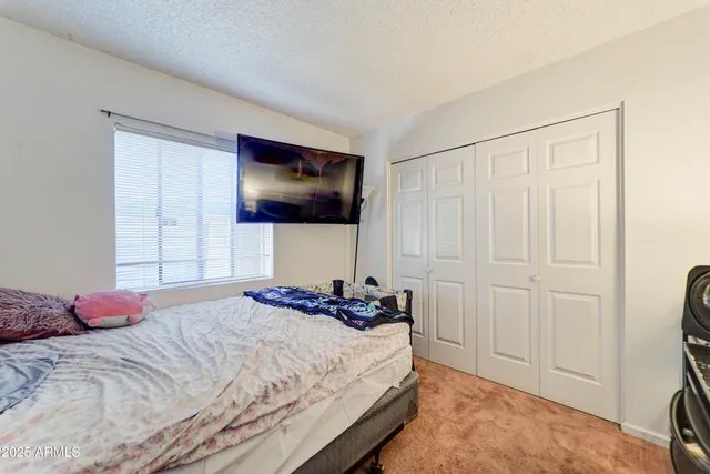 a bedroom with a bed and a flat tv screen