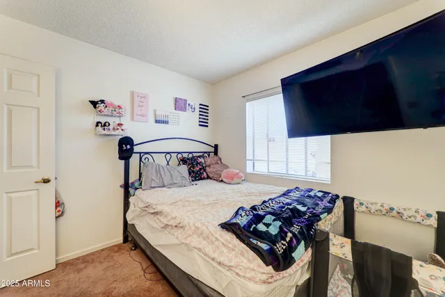 a bedroom with a bed and a flat screen tv