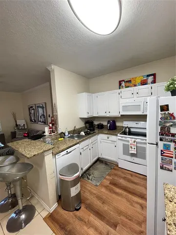a kitchen with a sink stove and white cabinets
