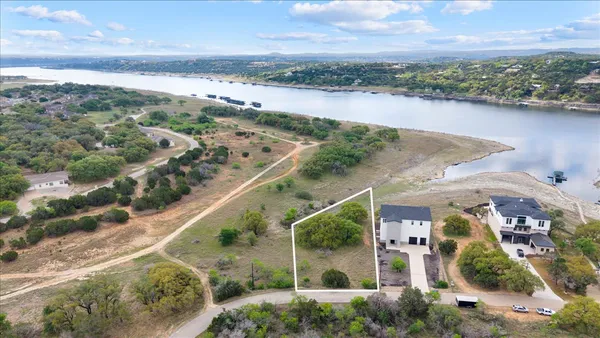 an aerial view of ocean and residential houses with outdoor space