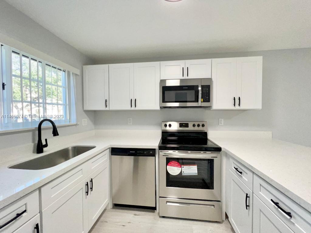 14116 Southwest 260th Street, Unit 106 Homestead, FL 33032 - Photo 1 of 24 a kitchen with white cabinets and appliances