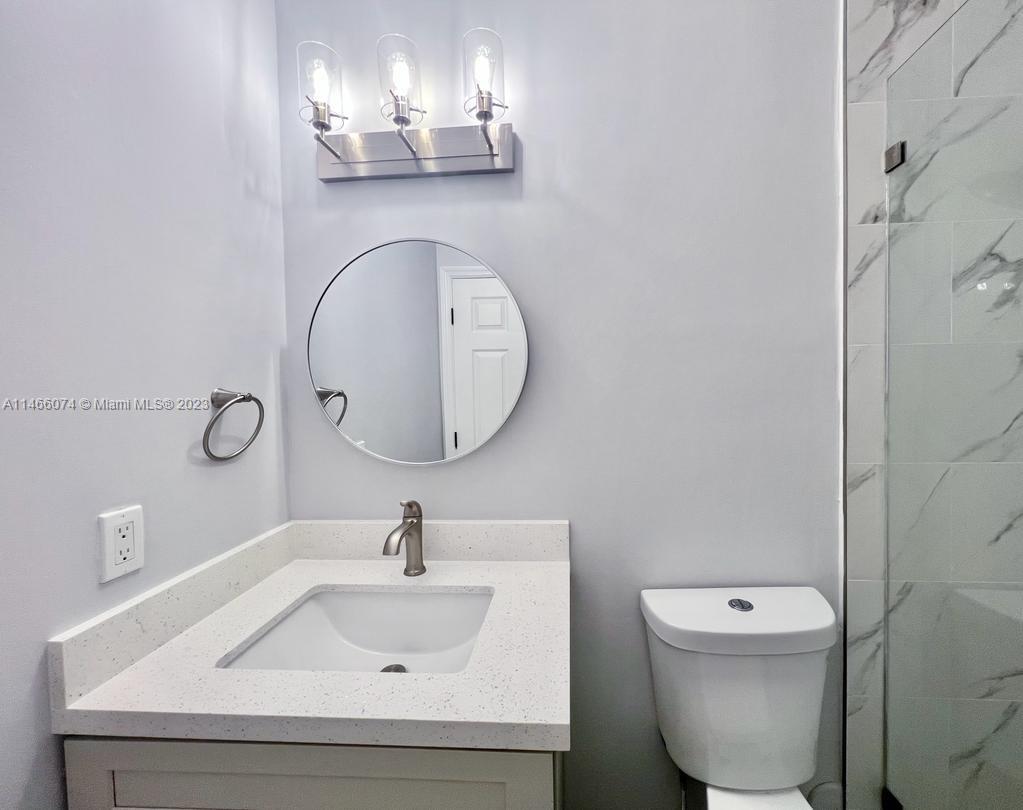 14116 Southwest 260th Street, Unit 106 Homestead, FL 33032 - Photo 13 of 24 a bathroom with a toilet sink and mirror