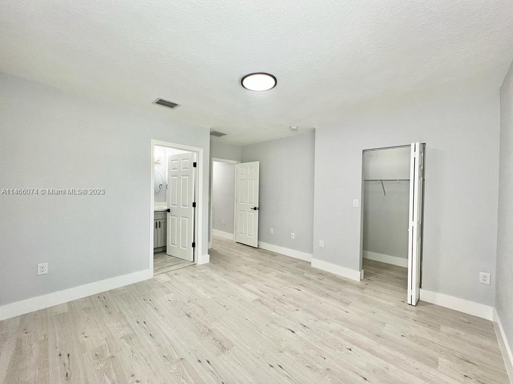 14116 Southwest 260th Street, Unit 106 Homestead, FL 33032 - Photo 15 of 24 an empty room with wooden floor and windows