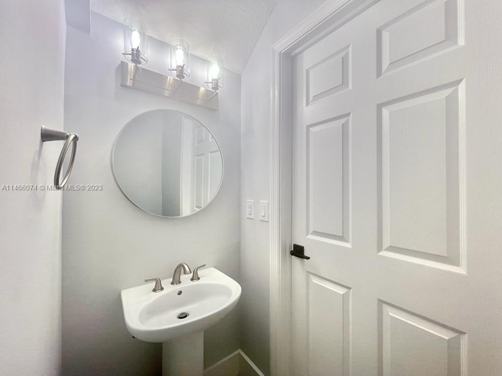 14116 Southwest 260th Street, Unit 106 Homestead, FL 33032 - Photo 17 of 24 a bathroom with a sink a mirror and vanity