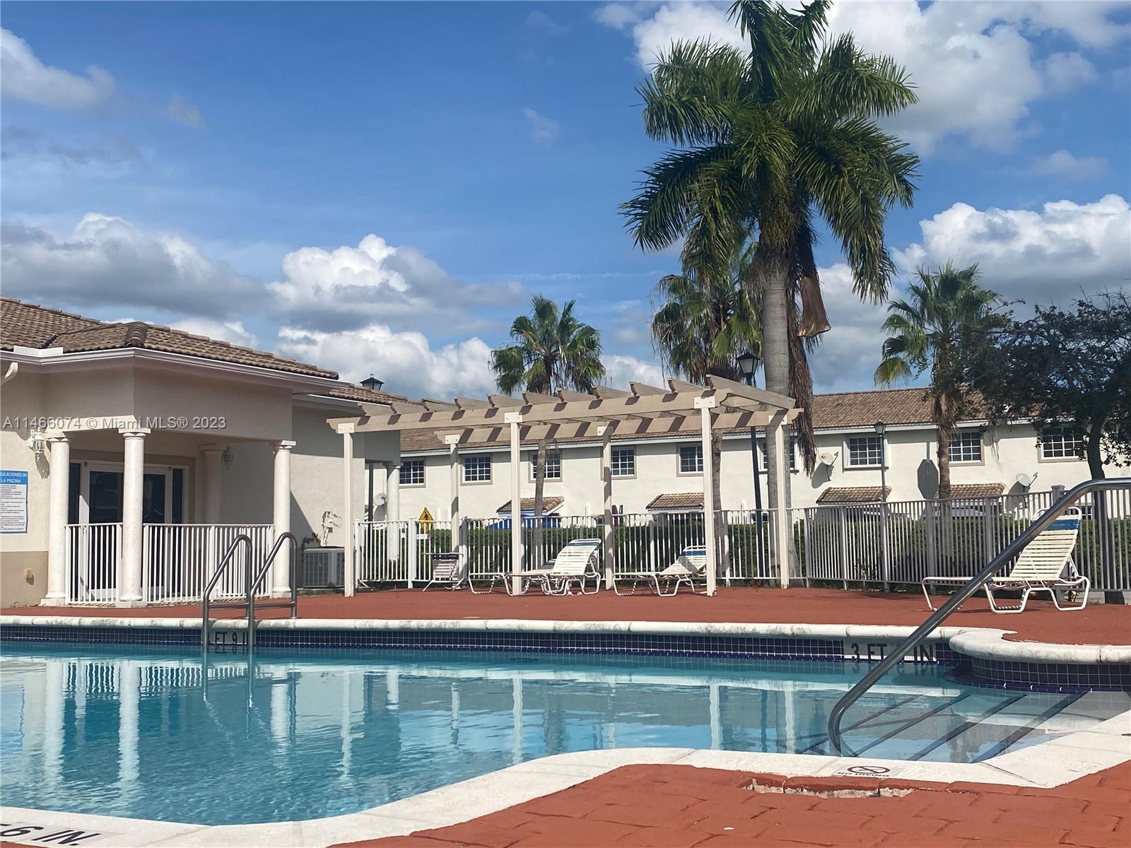 14116 Southwest 260th Street, Unit 106 Homestead, FL 33032 - Photo 22 of 24 a view of a swimming pool with a yard and plants