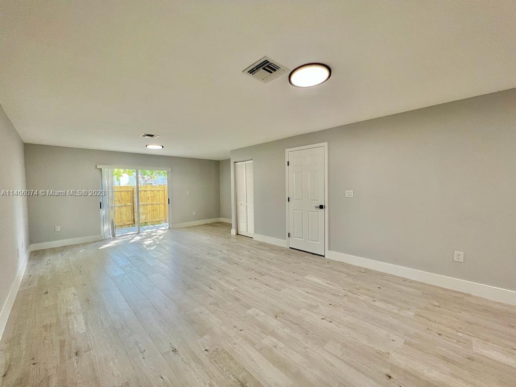 14116 Southwest 260th Street, Unit 106 Homestead, FL 33032 - Photo 5 of 24 a view of an empty room with wooden floor and a window