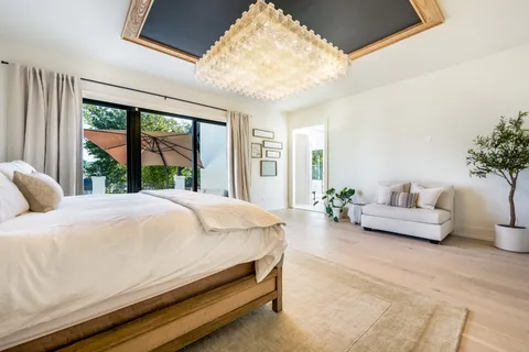 a bedroom with a large bed and a chandelier