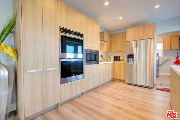 a kitchen with stainless steel appliances a refrigerator and a stove top oven