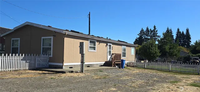 a view of a house with a yard and wooden fence