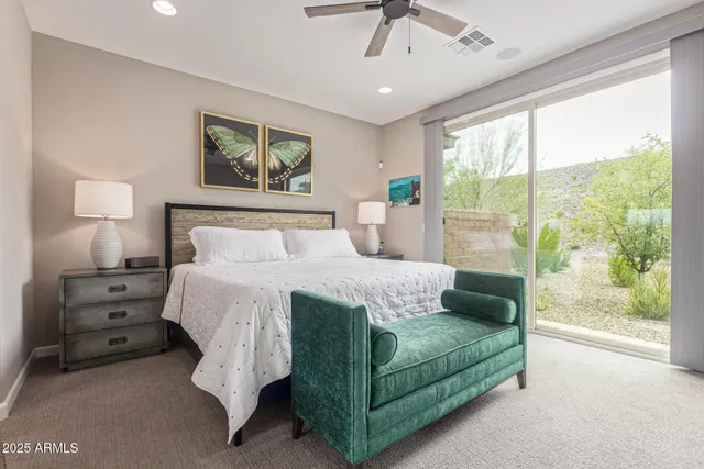 a bedroom with a bed a large window with outer view and couch