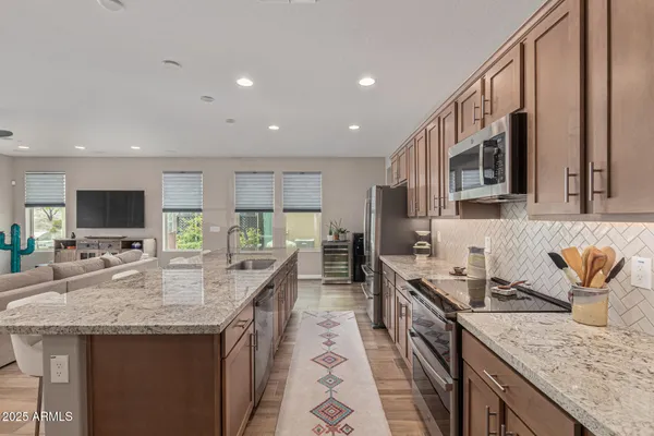 a kitchen with granite countertop a sink a counter top space appliances and cabinets