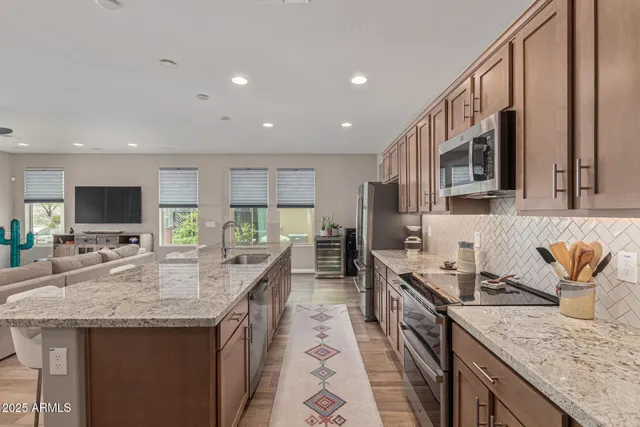 a kitchen with granite countertop a sink a counter top space appliances and cabinets