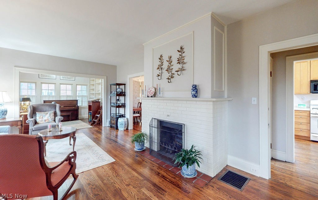3189 Chadbourne Road Cleveland, OH 44120 - Photo 3 of 25 Living room featuring a brick fireplace and dark hardwood / wood-style flooring