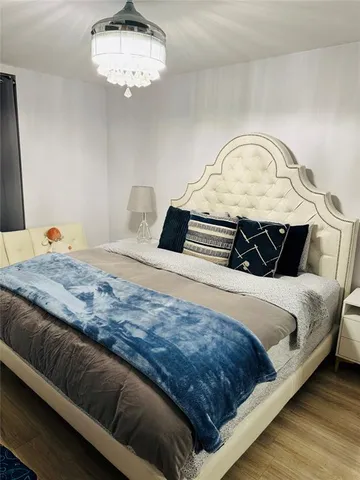a bedroom with a bed and a chandelier