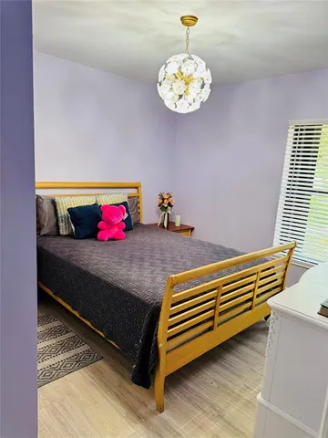 a bedroom with a bed and a chandelier