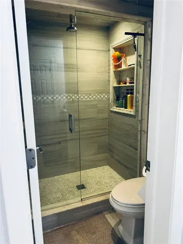 a bathroom with a toilet and a shower