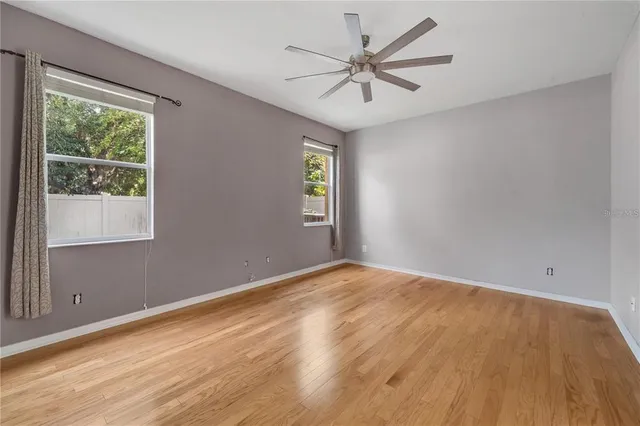 a view of a big room with wooden floor and windows in a room