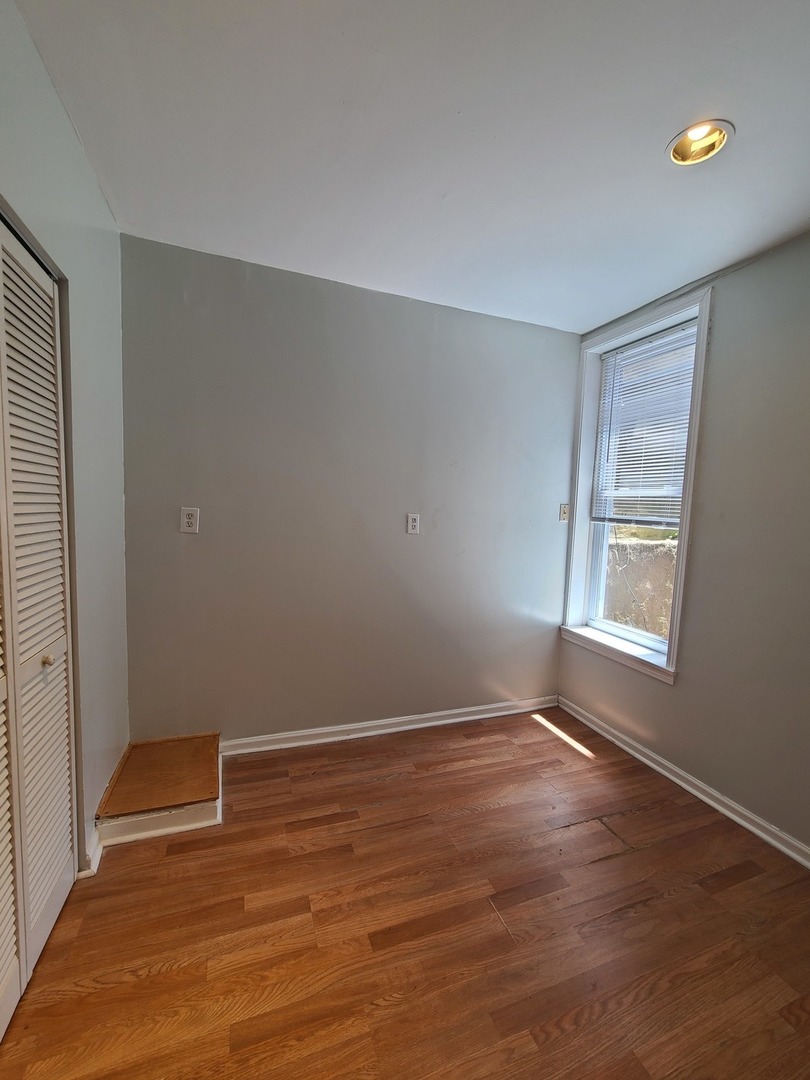 1531 West Highland Avenue, Unit 1 Chicago, IL 60660 - Photo 11 of 14 a view of an empty room with wooden floor and a window