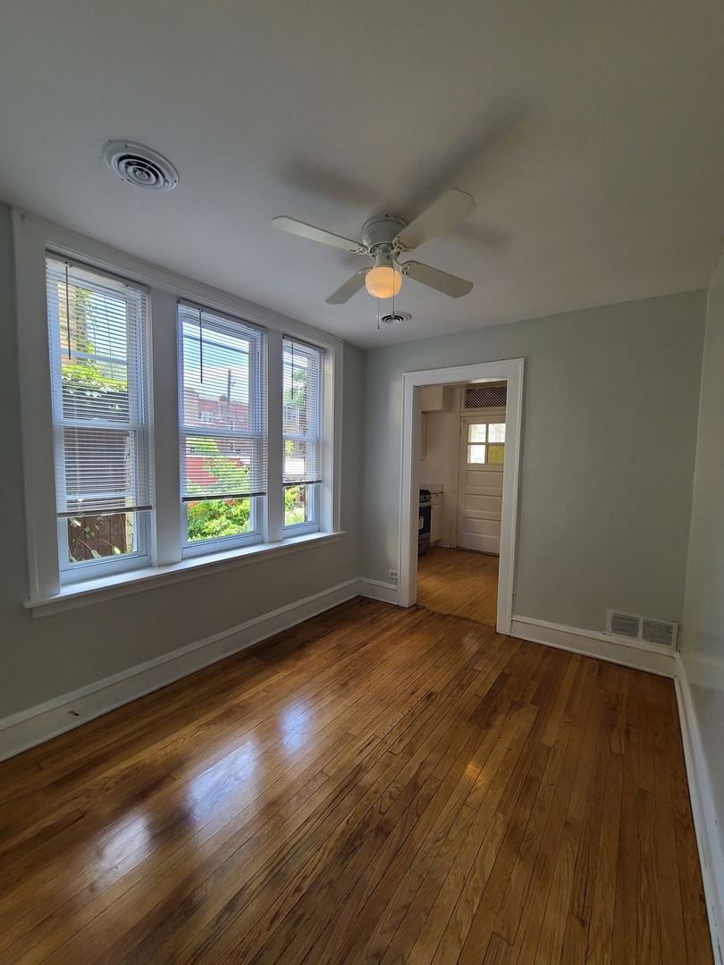 1531 West Highland Avenue, Unit 1 Chicago, IL 60660 - Photo 3 of 14 a view of an empty room with wooden floor and a window