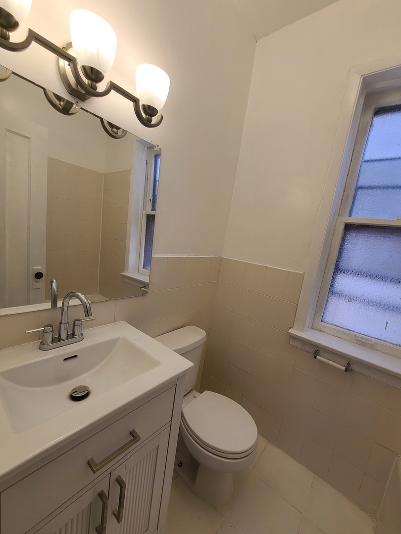 1531 West Highland Avenue, Unit 1 Chicago, IL 60660 - Photo 7 of 14 a bathroom with a sink a toilet and mirror