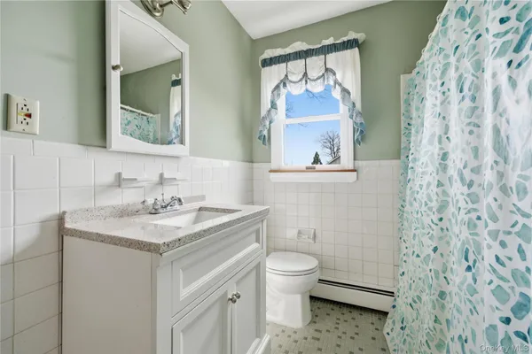 a bathroom with a sink toilet and mirror