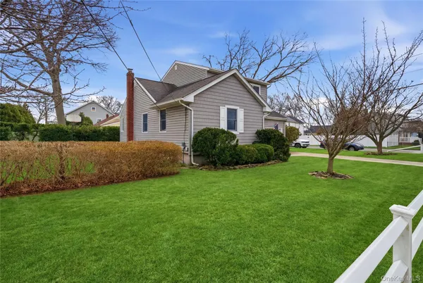 a front view of a house with a yard and trees