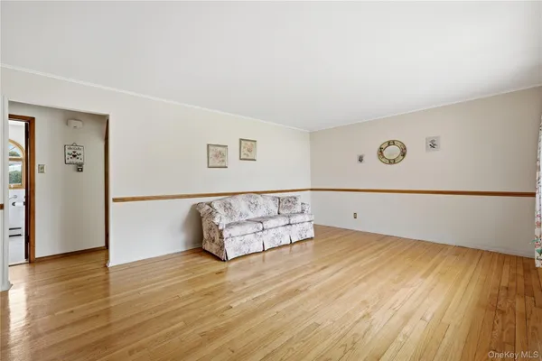 an empty room with wooden floor and window