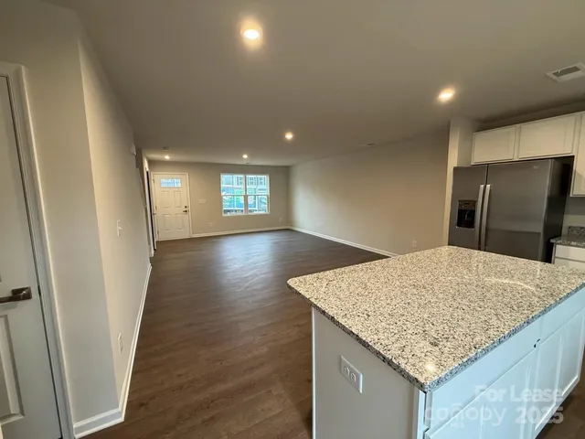 a kitchen with kitchen island a sink and wooden floor