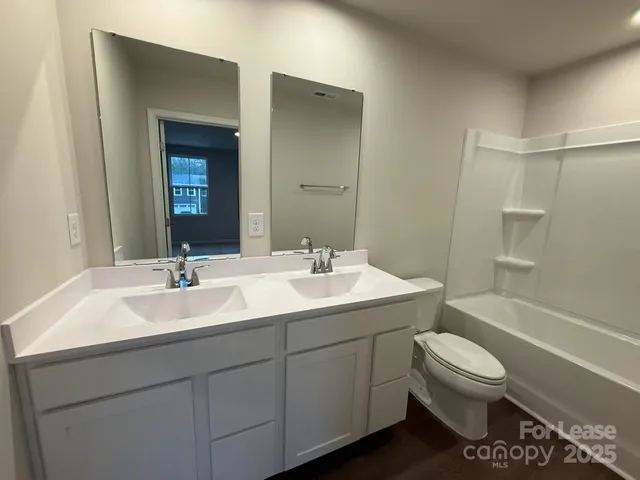 a bathroom with a sink toilet vanity and tub