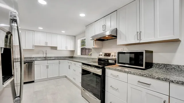 a bathroom with a granite countertop toilet a sink and a mirror
