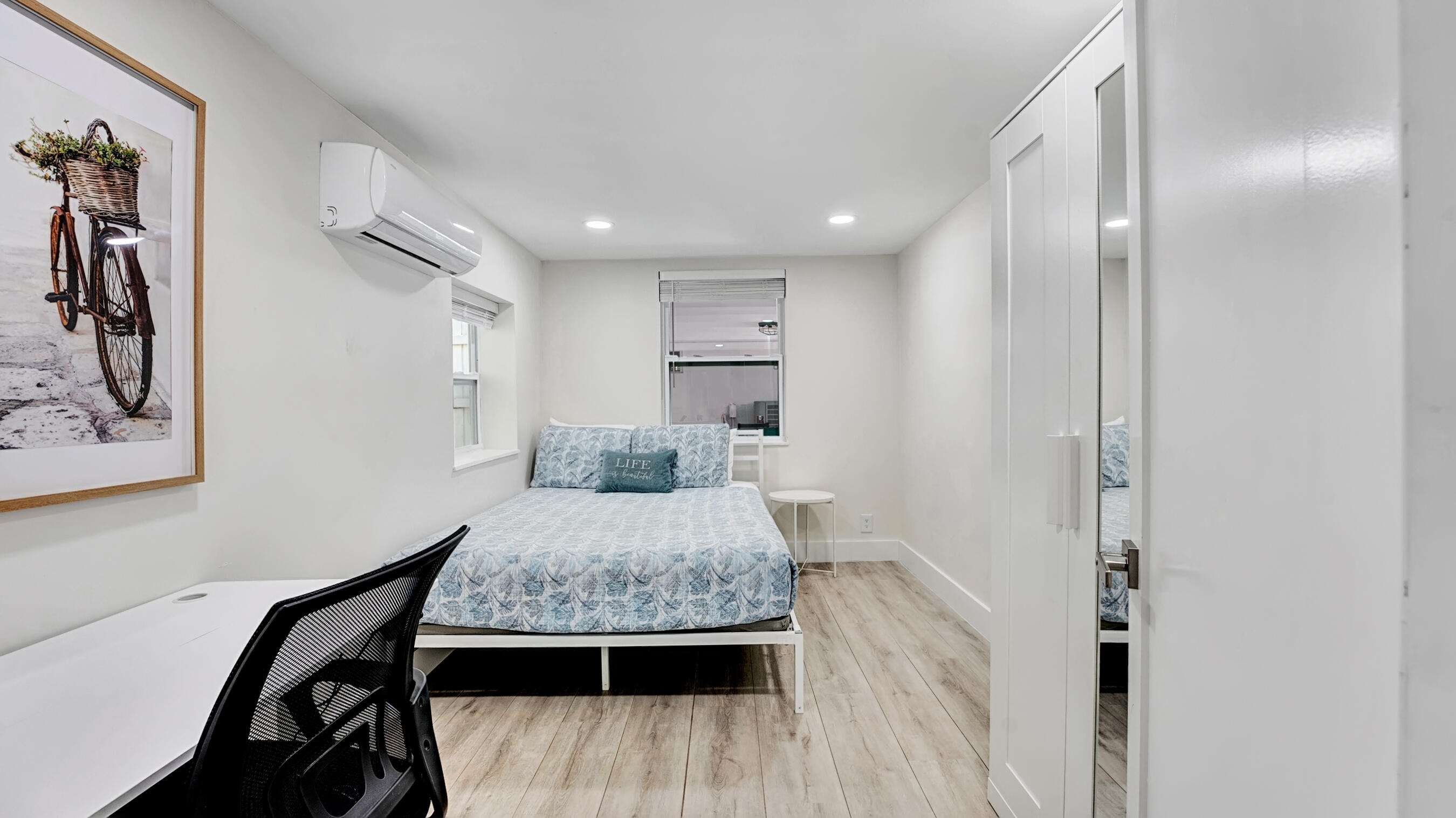 218 Northeast 10th Street Delray Beach, FL 33444 - Photo 37 of 43 a bedroom with a bed and a table with wooden floor