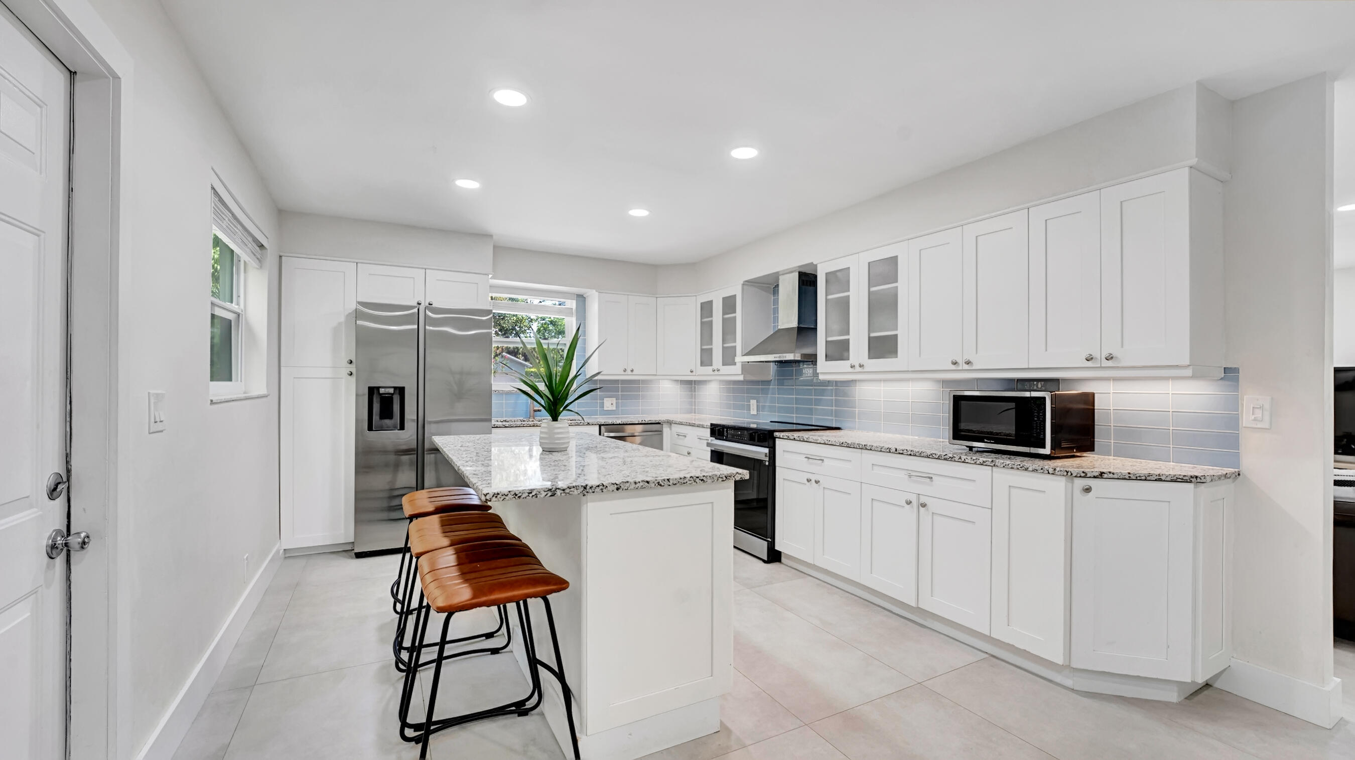 218 Northeast 10th Street Delray Beach, FL 33444 - Photo 9 of 43 a kitchen with stainless steel appliances kitchen island granite countertop a sink and a stove