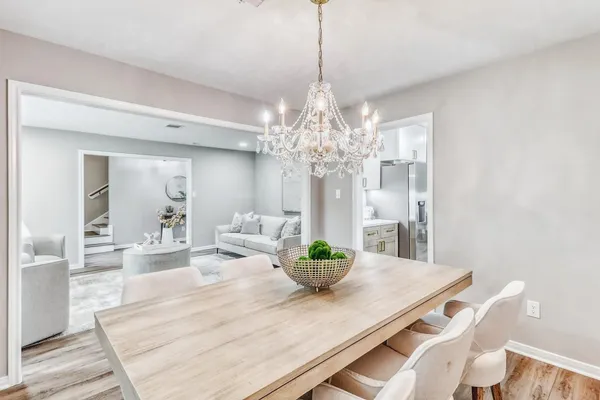 a view of a dining room with furniture a chandelier and wooden floor