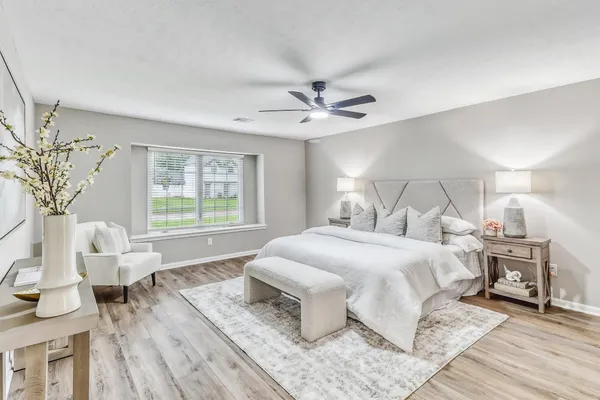 a bedroom with a large bed and a chandelier