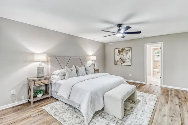 a spacious bedroom with a bed and a chandelier