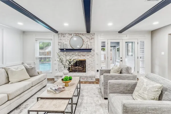 a living room with furniture a fireplace and a large window