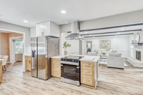 a kitchen view with stainless steel appliances kitchen island granite countertop a stove and refrigerator