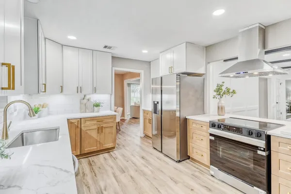 a kitchen with stainless steel appliances kitchen island granite countertop a refrigerator and a stove top oven